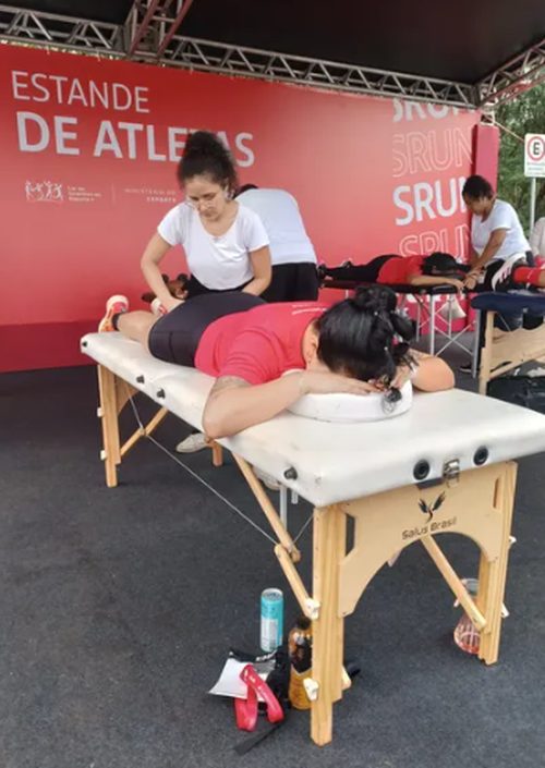 Atendimento de massagem em estande de atletas durante evento esportivo