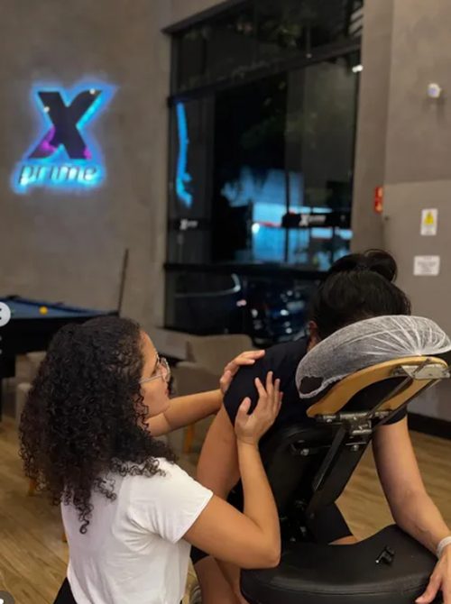 Sessão de quick massage na cadeira de massagem em espaço com jardim